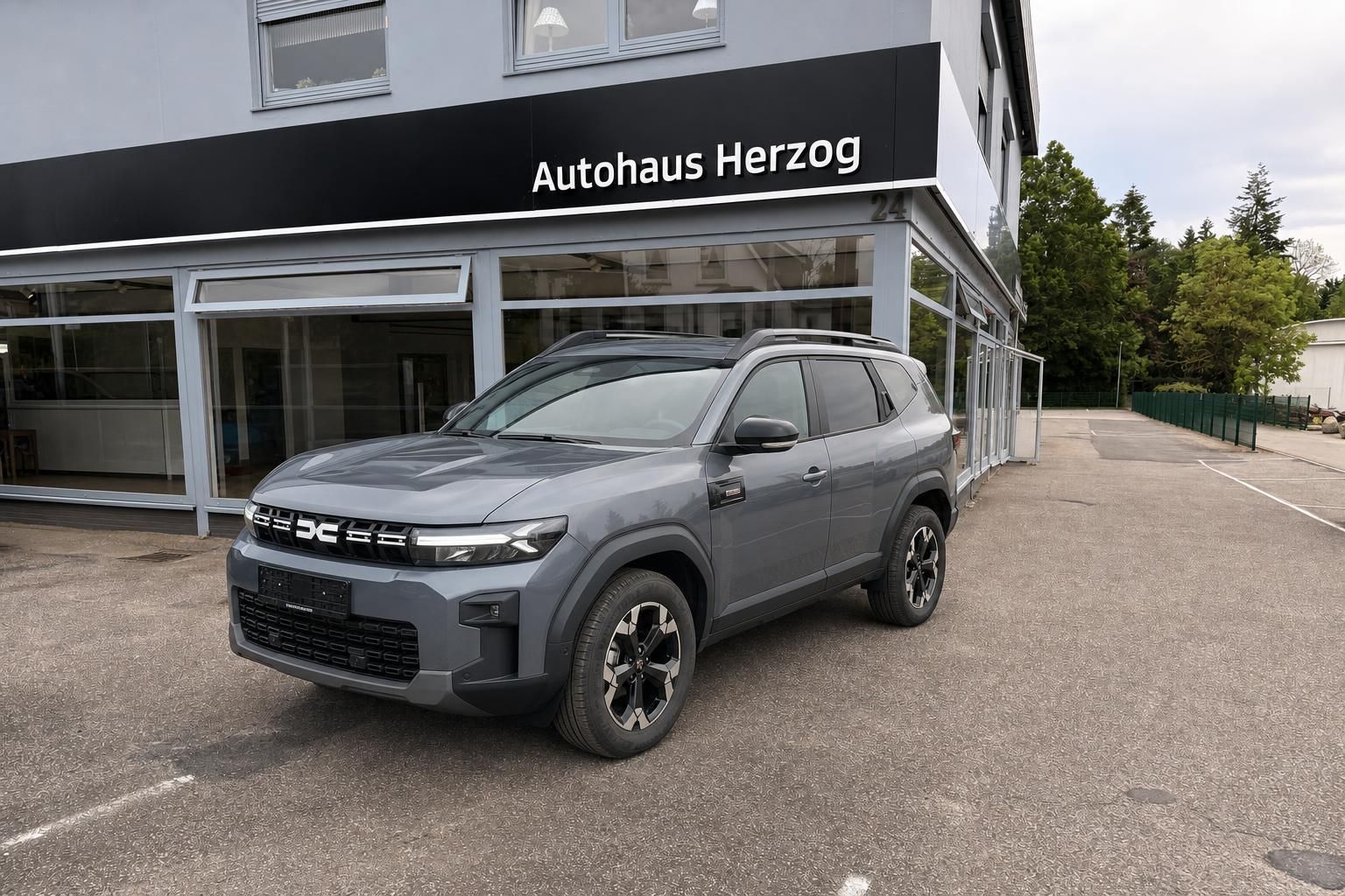 Grauer SUV vor Autohaus Herzog Gebäude - Außenansicht Schrägperspektive