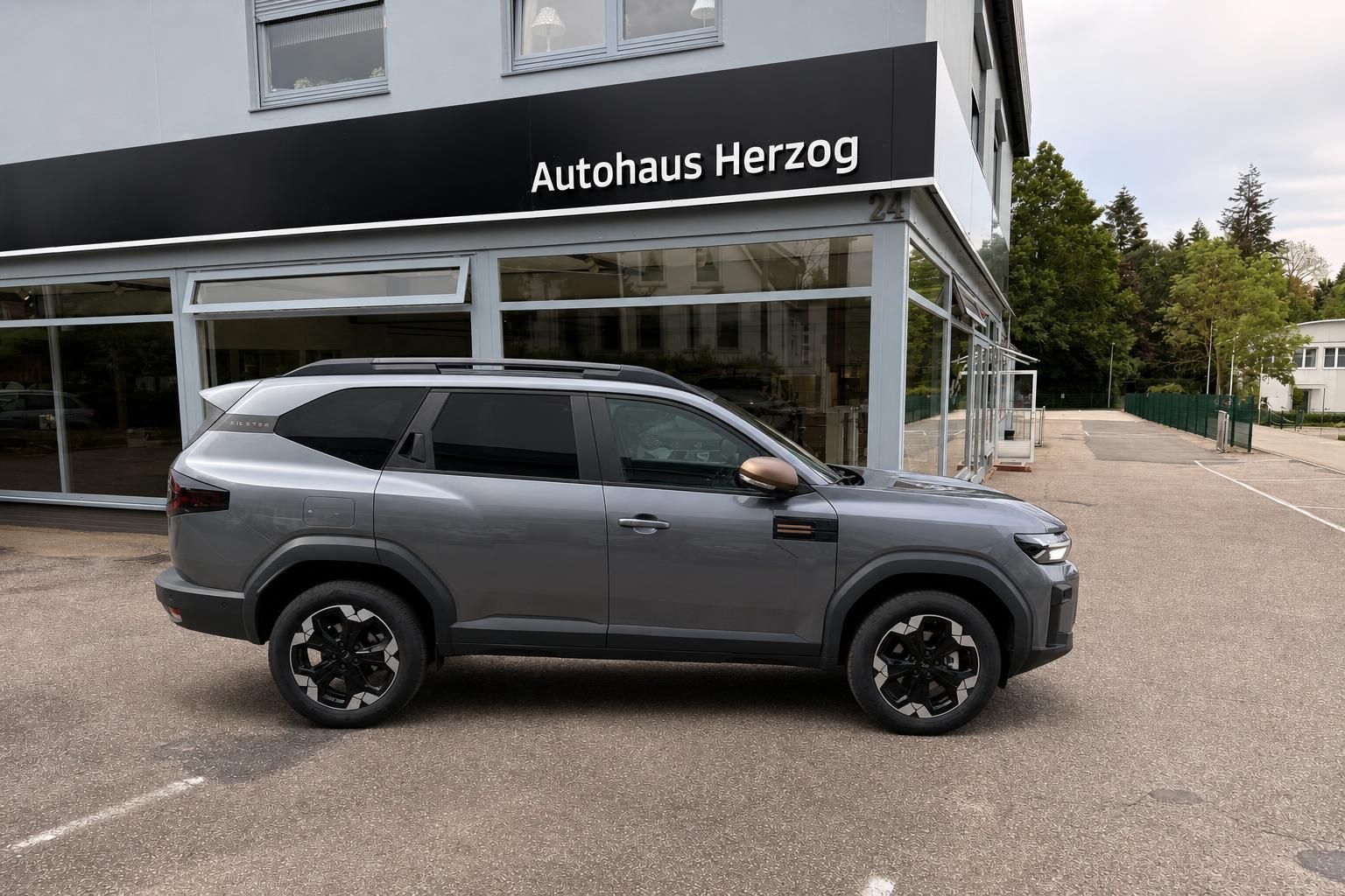 Grauer SUV Seitenansicht vor Autohaus Herzog - modernes Fahrzeug mit schwarzen Felgen