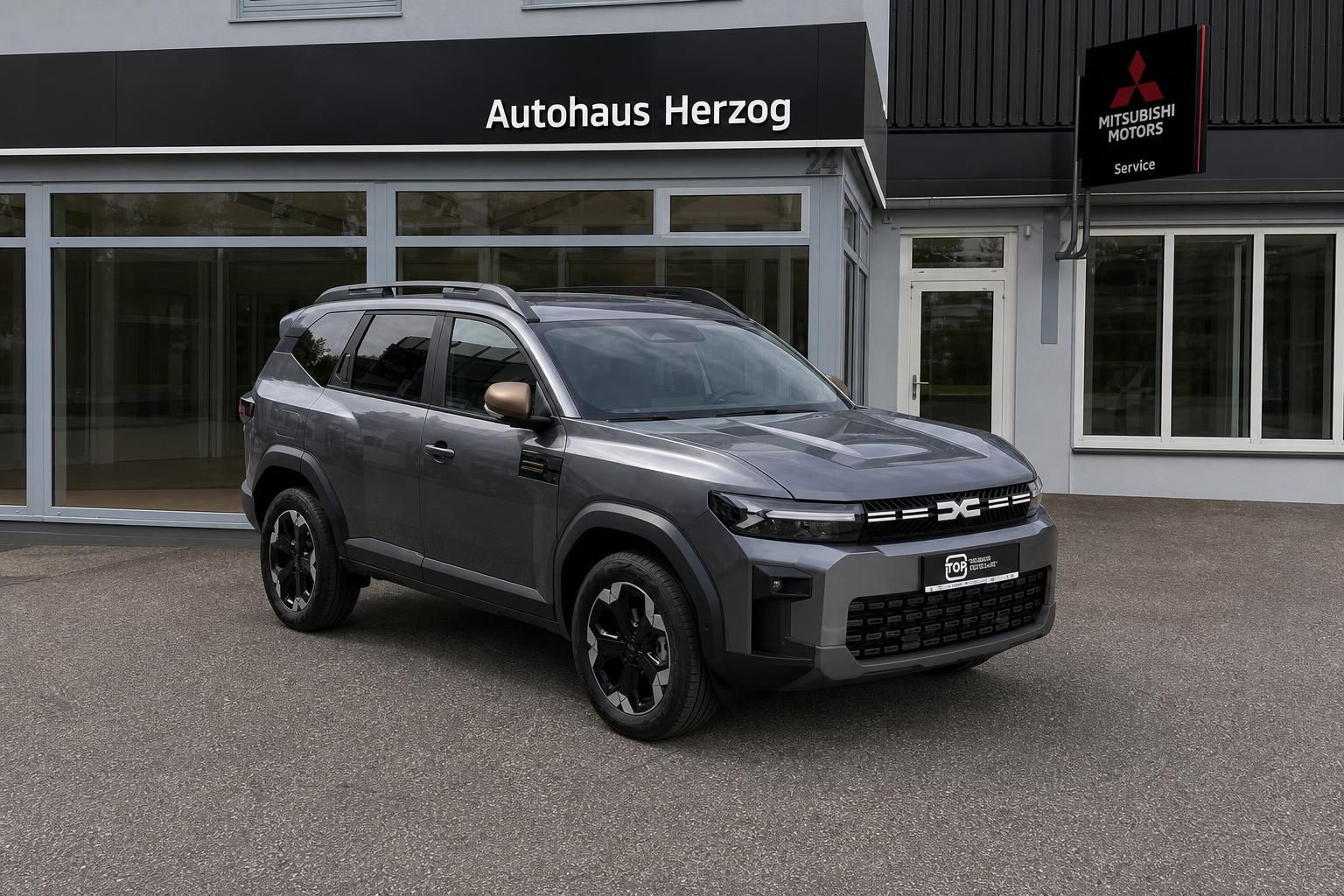 Grauer SUV Schrägansicht vorne vor Mitsubishi Autohaus - moderne Frontpartie mit LED-Scheinwerfern