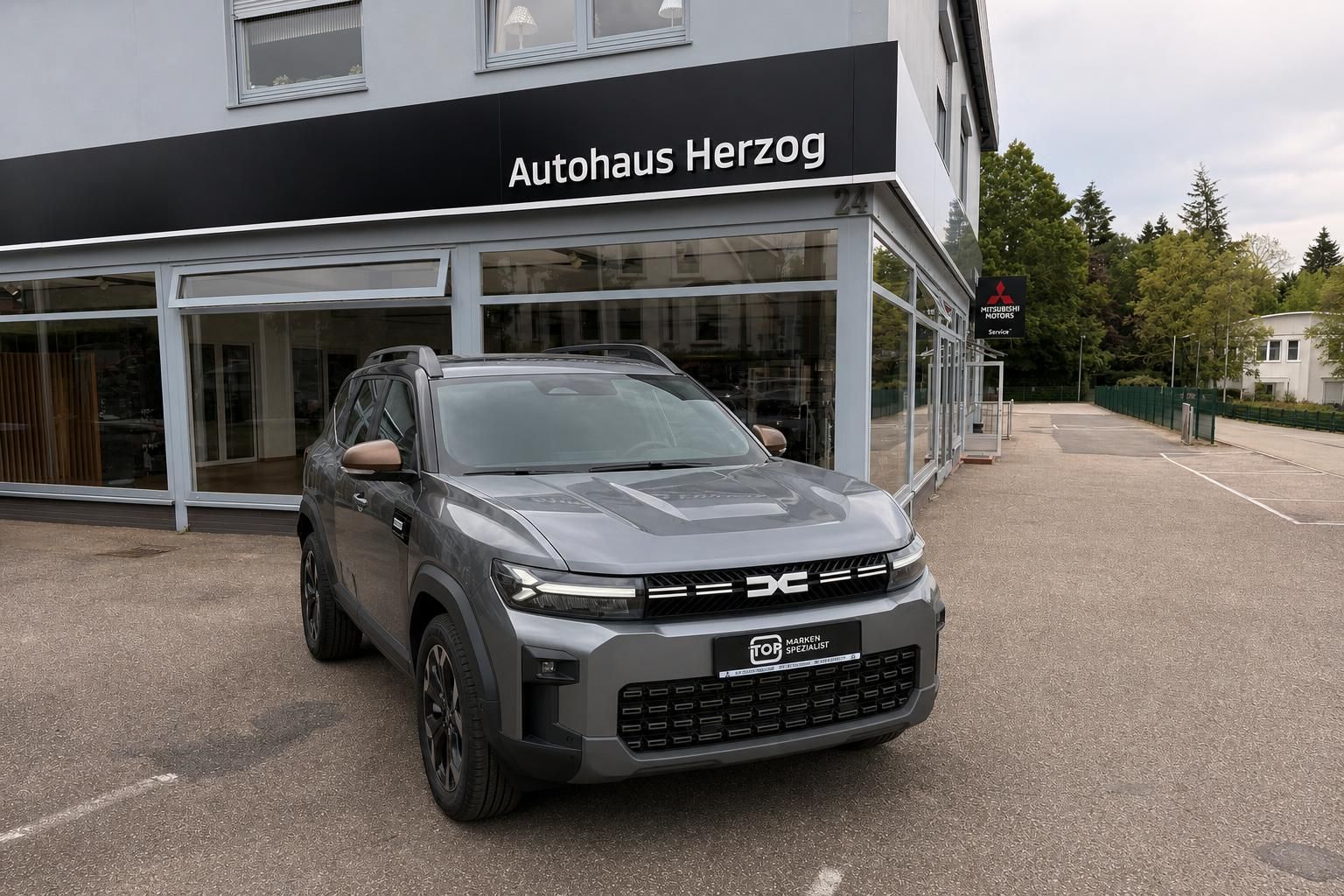 Grauer SUV Frontansicht vor Autohaus Herzog - markante Fahrzeugfront mit schwarzen Akzenten