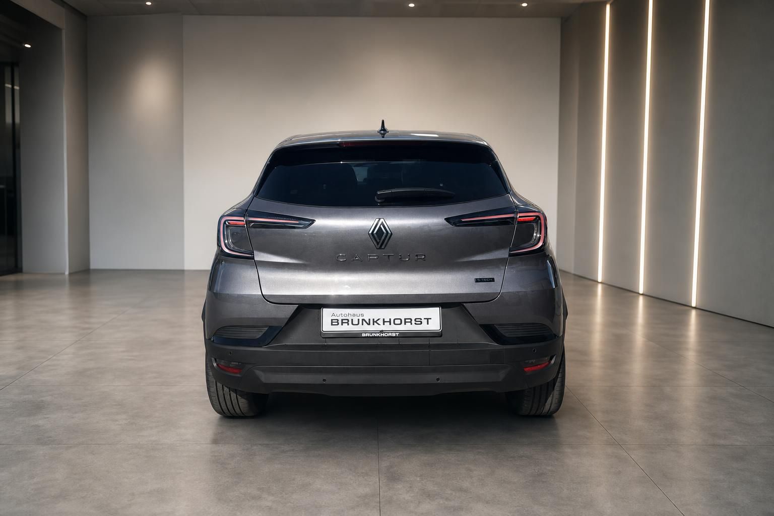 Renault Captur Heckansicht in grau - Elektro-SUV im modernen Showroom