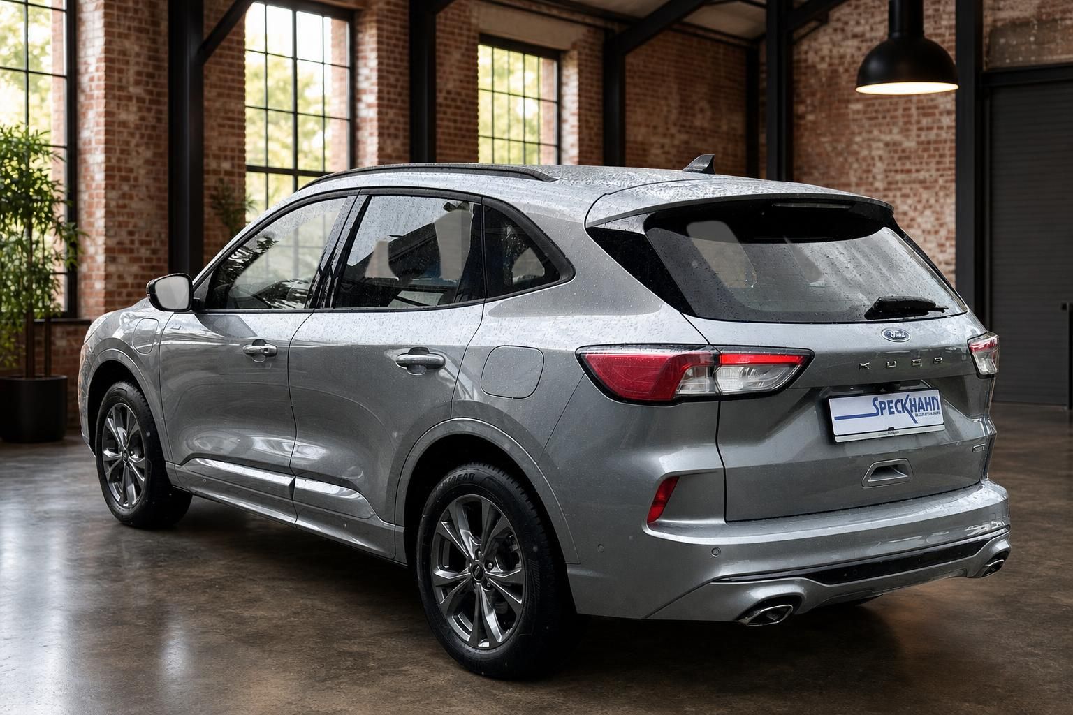 Ford Kuga in Grau, Heck-Seitenansicht in Loft mit Ziegelwand