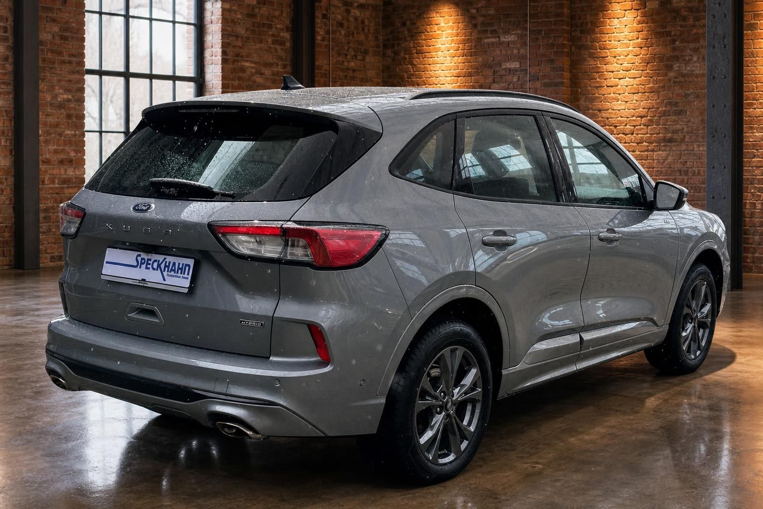 Ford Kuga Hybrid grau, Heck-Seitenansicht in Industriehalle