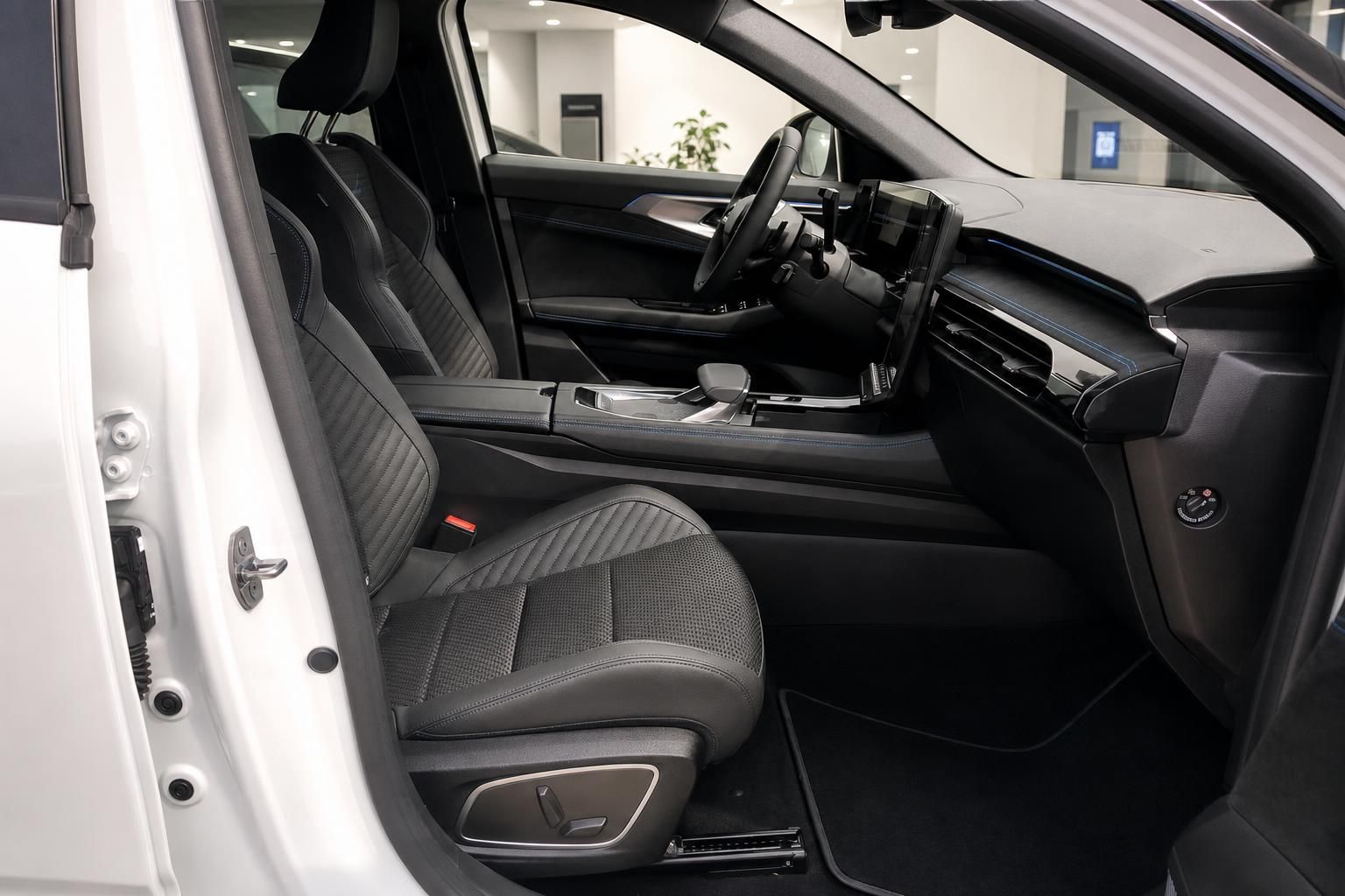 Fahrzeuginnenraum mit schwarzen Sportsitzen und modernem Armaturenbrett in weißem Auto