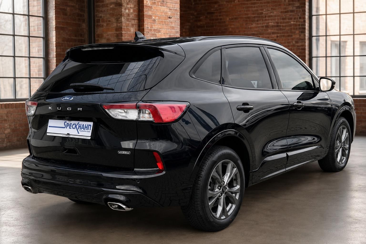 Ford Kuga Hybrid schwarz Heckansicht seitlich in Loft-Halle