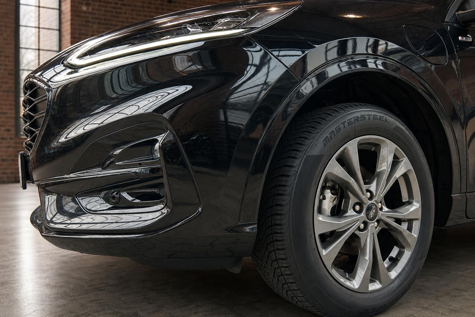 Ford Kuga schwarz Detailansicht vorderer Radlauf und Leichtmetallfelge
