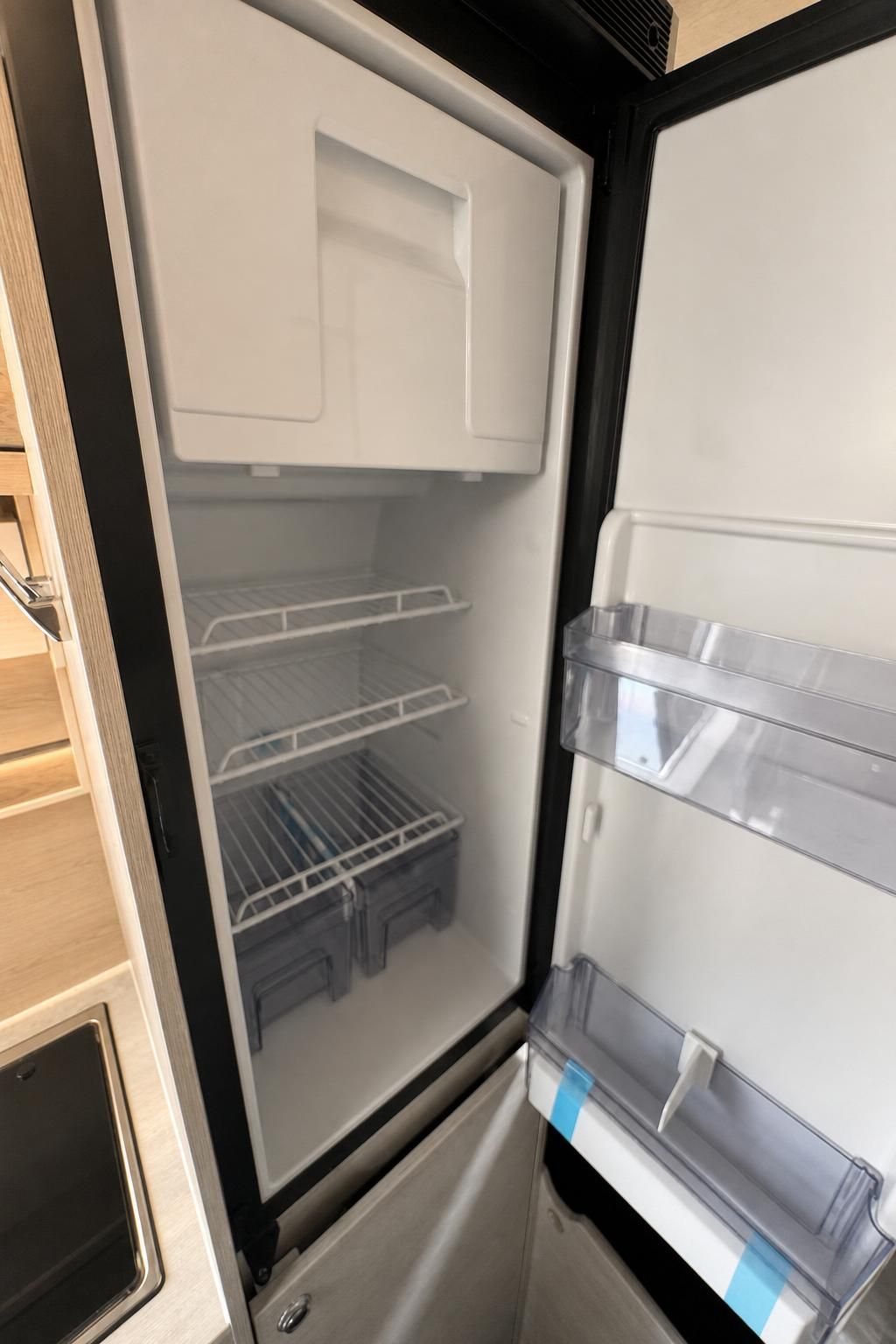 Geoeffneter Kuehlschrank im Wohnmobil mit Ablagefaechern