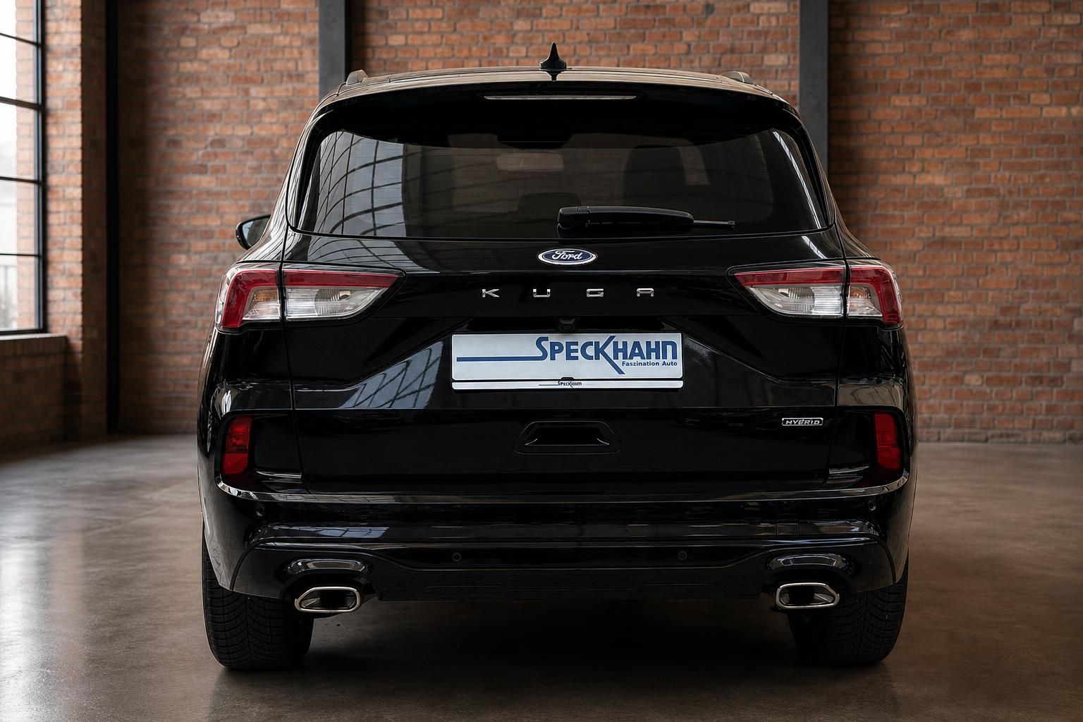 Ford Kuga Hybrid schwarz direkte Heckansicht vor Backsteinwand