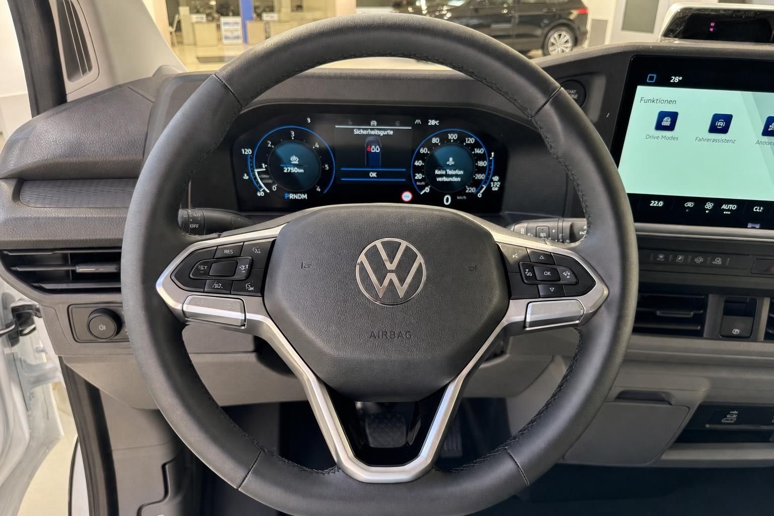 VW Lenkrad mit Multifunktionstasten und digitalem Cockpit im Innenraum