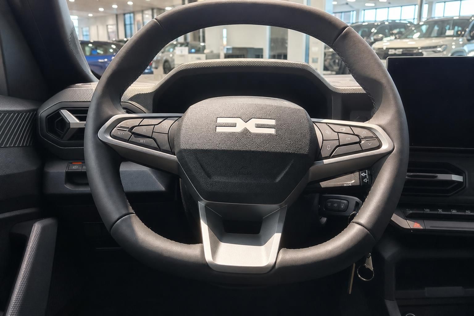 Dacia Lenkrad Detailaufnahme mit Markenlogo und Bedienknöpfen