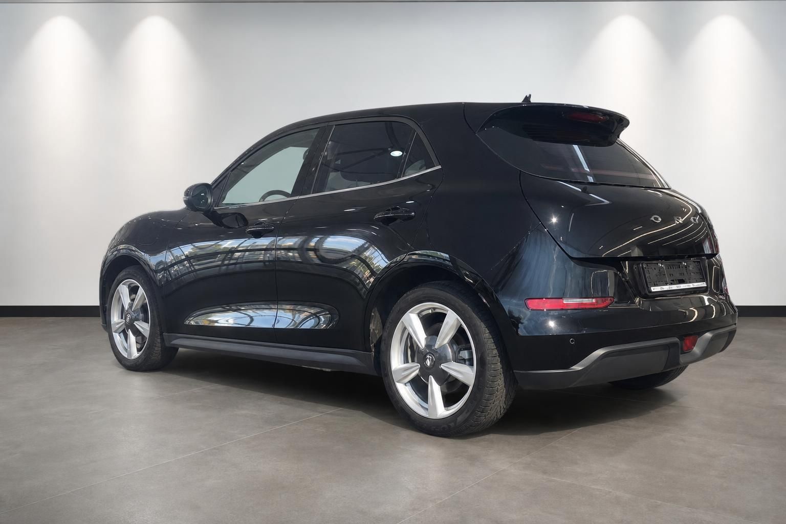 Schwarzes Elektro-SUV Heckansicht schräg links im Fotostudio mit Alufelgen