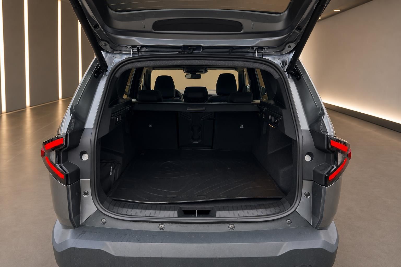 Kofferraum eines grauen SUVs mit geöffneter Heckklappe und schwarzer Kofferraummatte