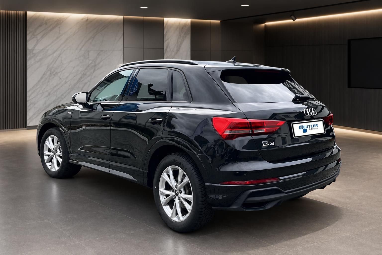Audi Q3 schwarz Heck-Seitenansicht im Showroom
