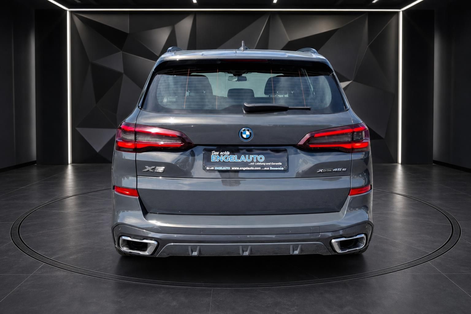 BMW X5 xDrive45e in Grau, Heckansicht auf Drehbühne im Autohaus