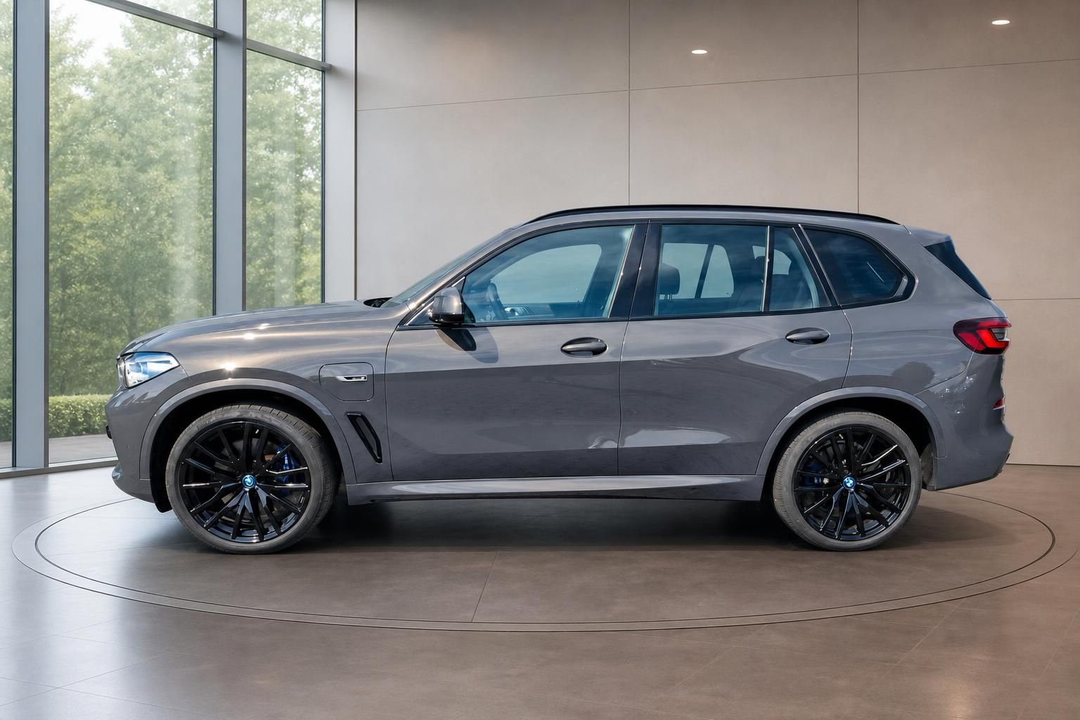 BMW X5 in Grau, Seitenansicht mit schwarzen Felgen im Showroom