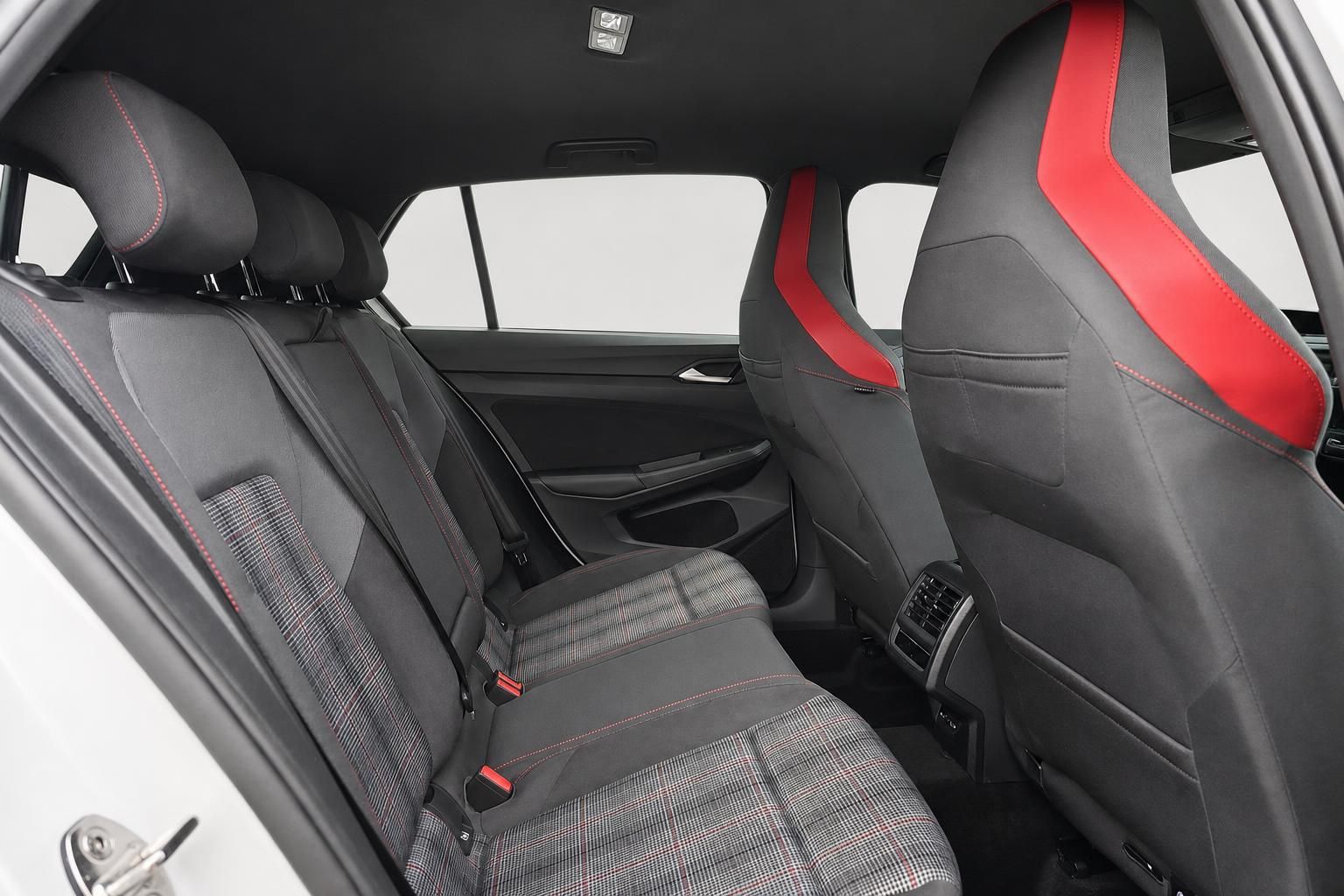 Innenraum VW Golf GTI mit karierten Sitzen und roten Ziernähten im Rücksitzbereich
