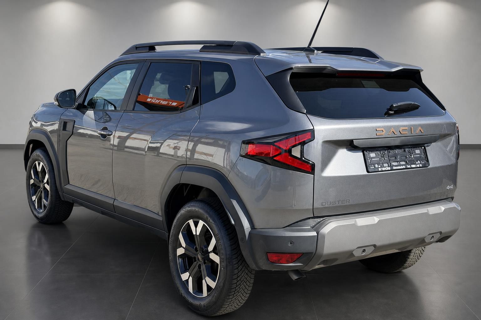 Dacia Duster 4x4 grau Heckansicht seitlich im Showroom