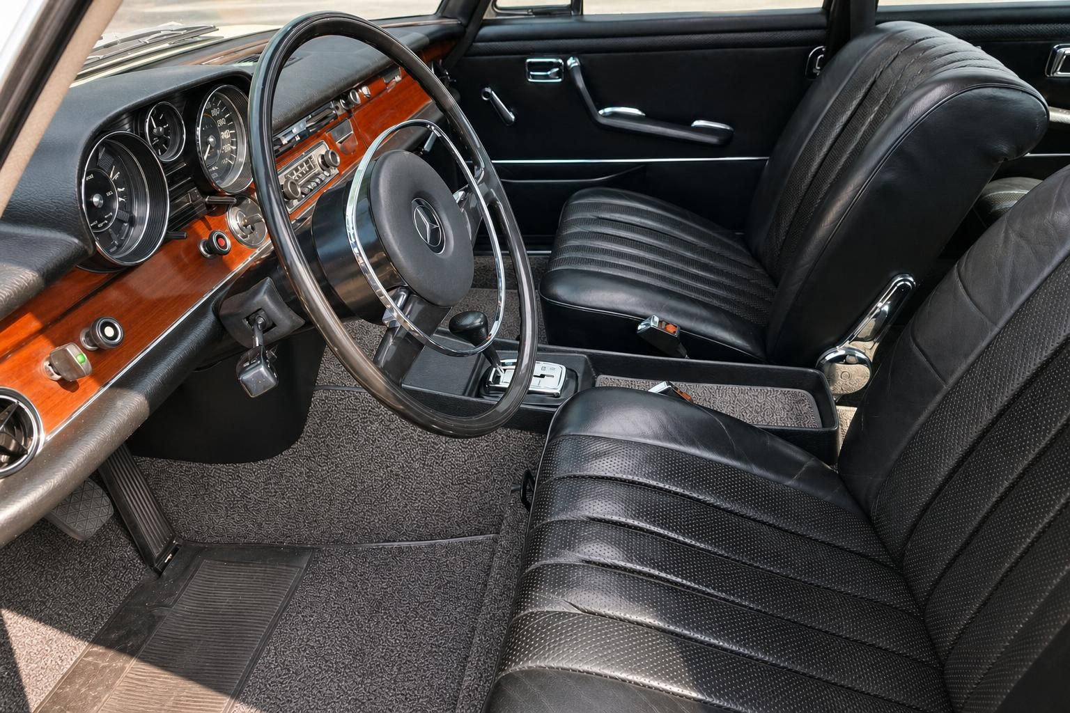 Mercedes-Benz Klassiker Innenraum – Fahrersitz mit schwarzem Leder, Holzarmaturenbrett und Lenkrad