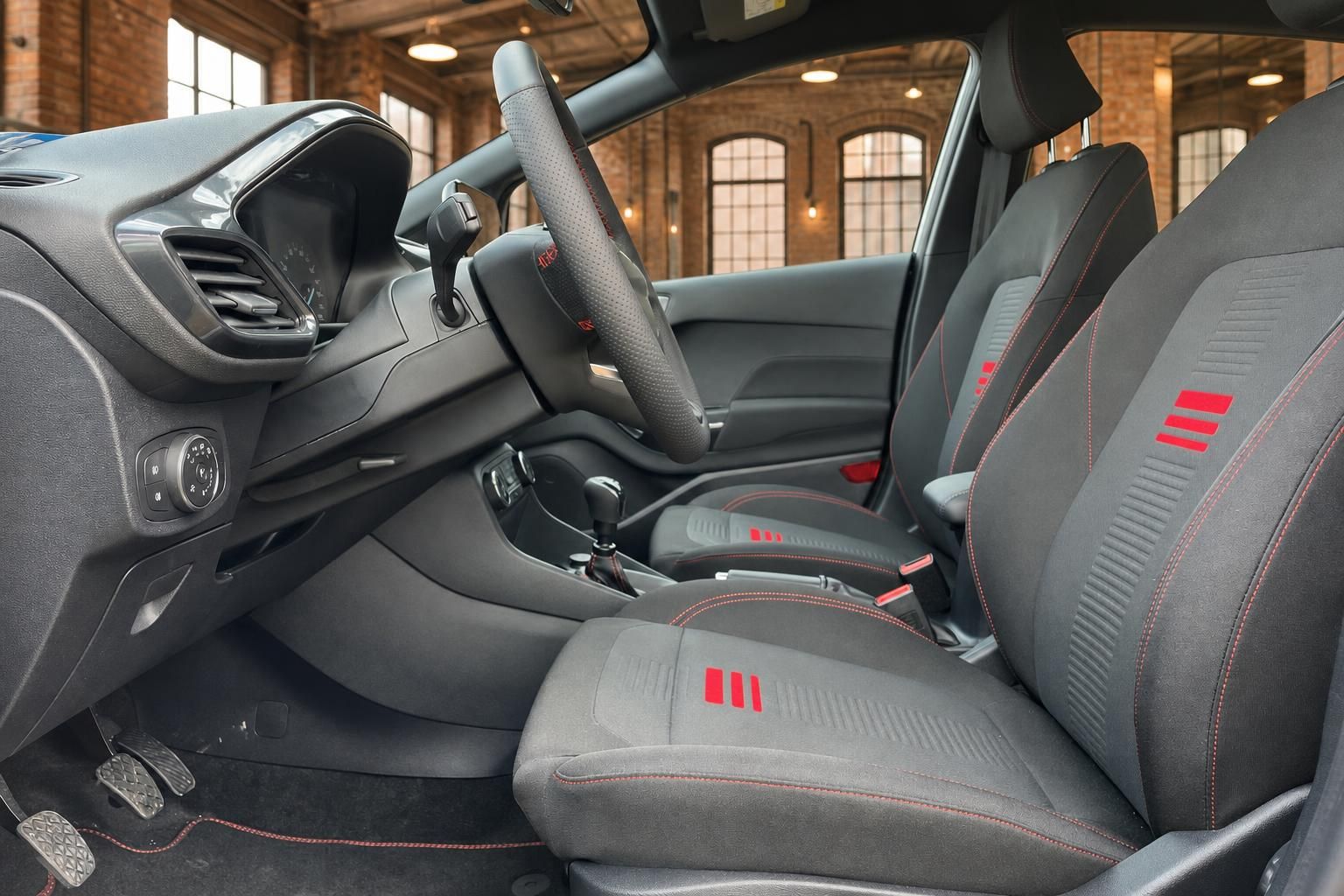 Ford Fiesta Innenraum Fahrersitz mit schwarzen Sportsitzen, roten Nähten und Lenkrad