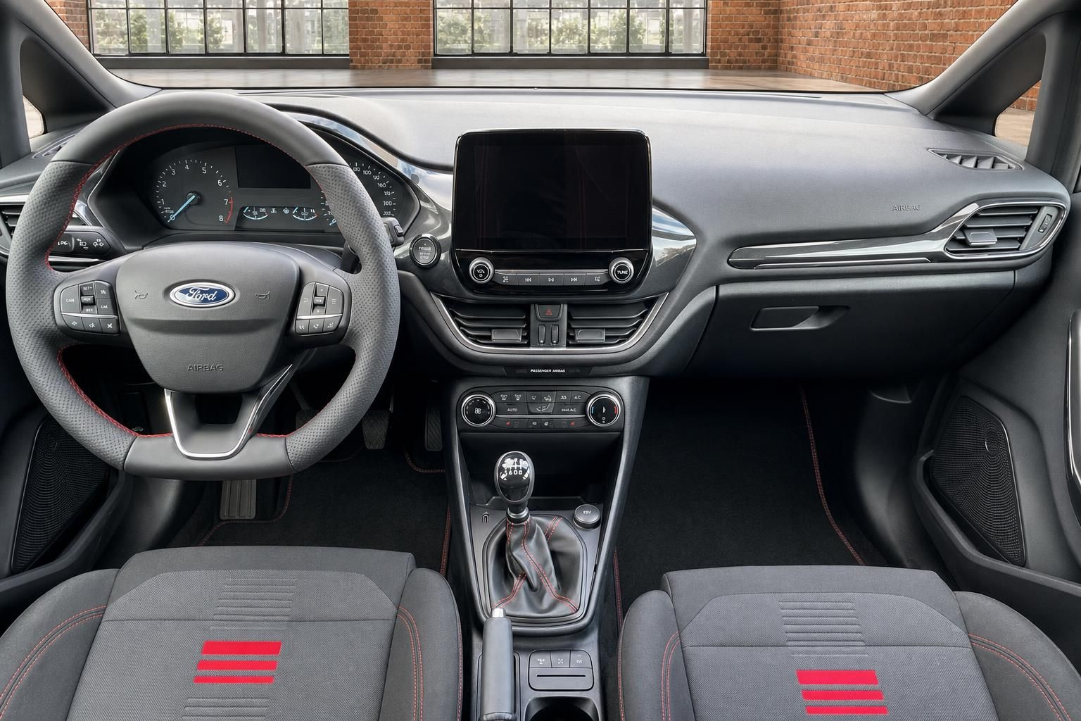 Ford Fiesta Innenraum – Armaturenbrett mit Touchscreen, Ford-Lenkrad und Sportsitze mit roten Streifen