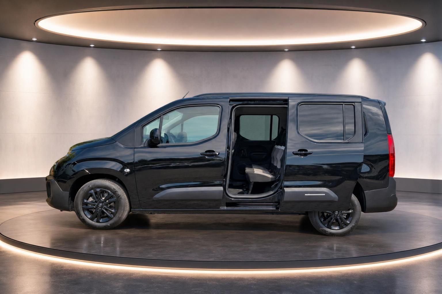 Citroën Berlingo schwarz Seitenansicht mit offener Schiebetür - Kompaktvan Innenraum sichtbar auf Showroom-Bühne