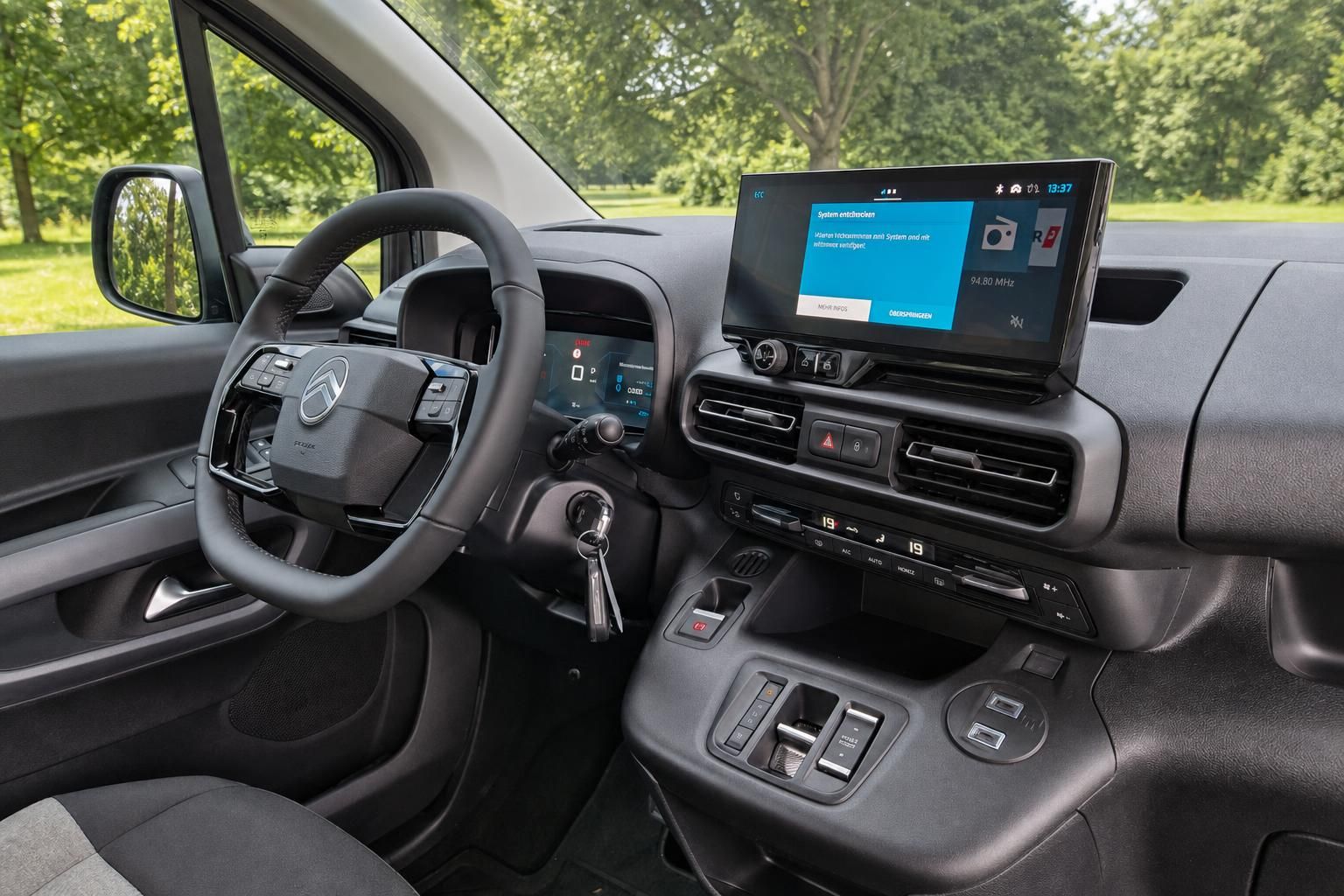 Moderner Fahrzeug-Innenraum mit Touchscreen-Display und digitalem Cockpit in grauer Ausstattung