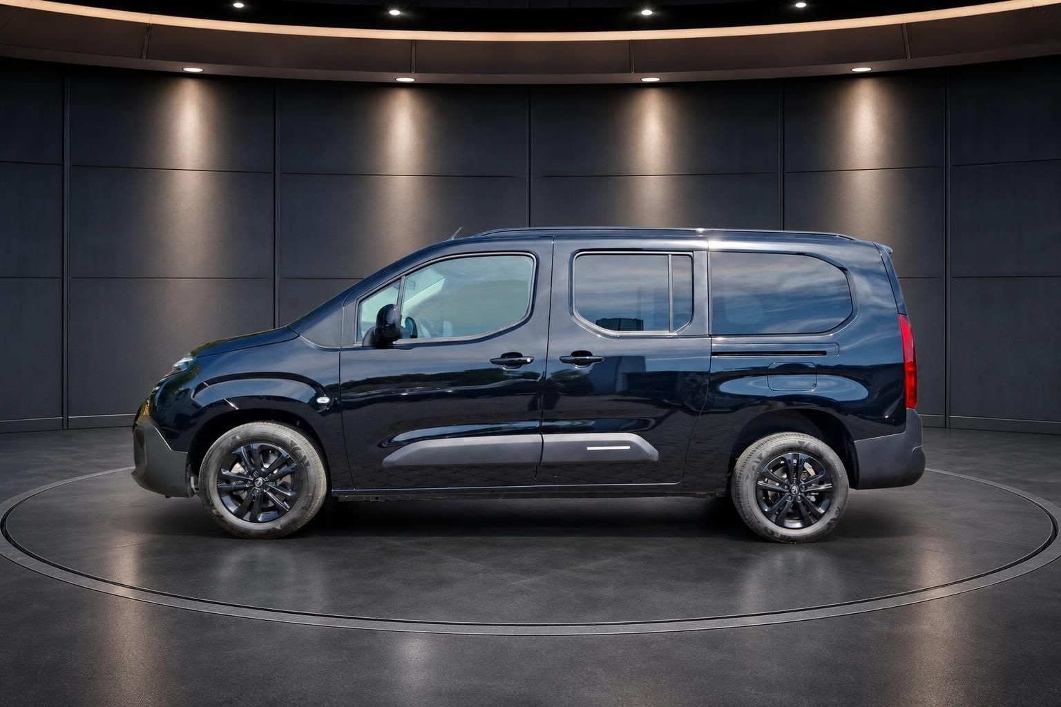 Citroën Berlingo schwarz Seitenansicht links - Kompaktvan mit schwarzen Felgen auf Drehscheibe im Showroom