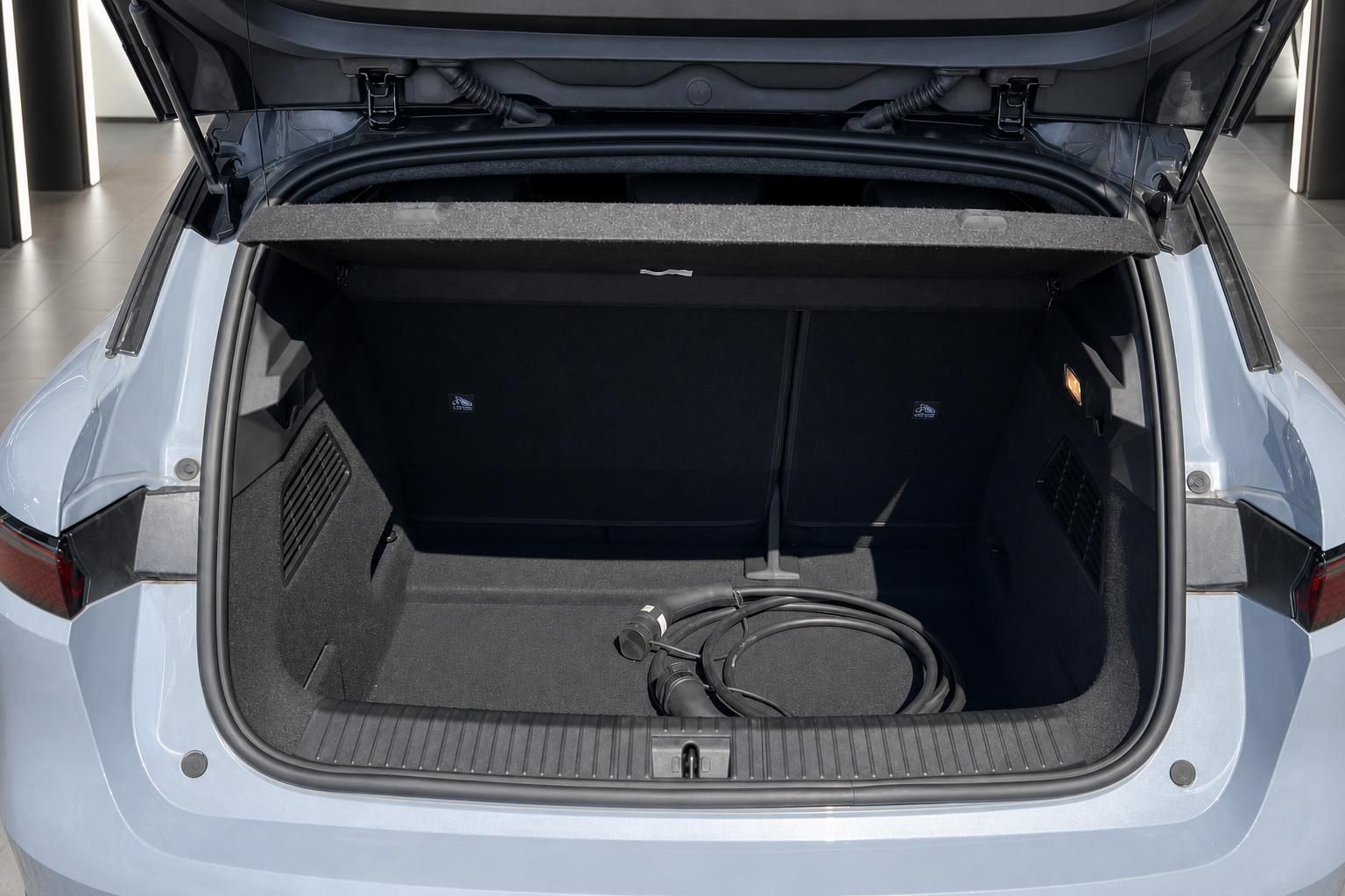 Offener Kofferraum eines weißen Fahrzeugs mit Ladekabel für Elektroauto