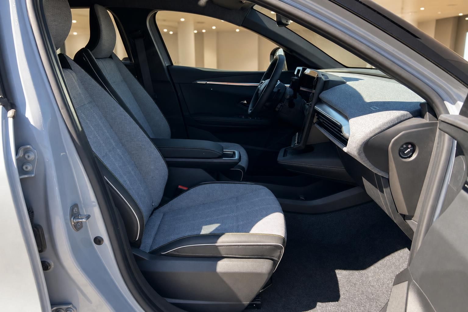 Innenraum Fahrzeug mit blauen Stoffsitzen und modernem Cockpit im Autohaus