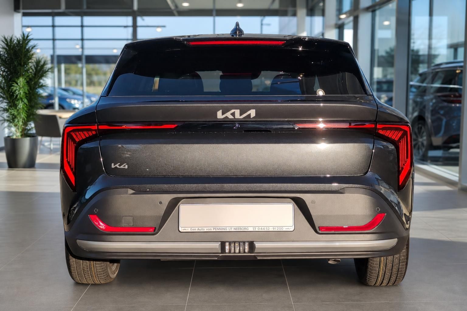 Kia K4 in Schwarz, direkte Heckansicht mit Kennzeichen