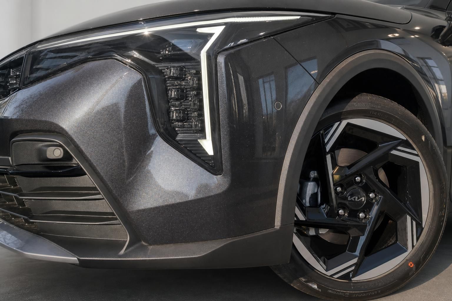 Kia Frontpartie mit LED-Scheinwerfer und schwarzer Leichtmetallfelge Detailansicht
