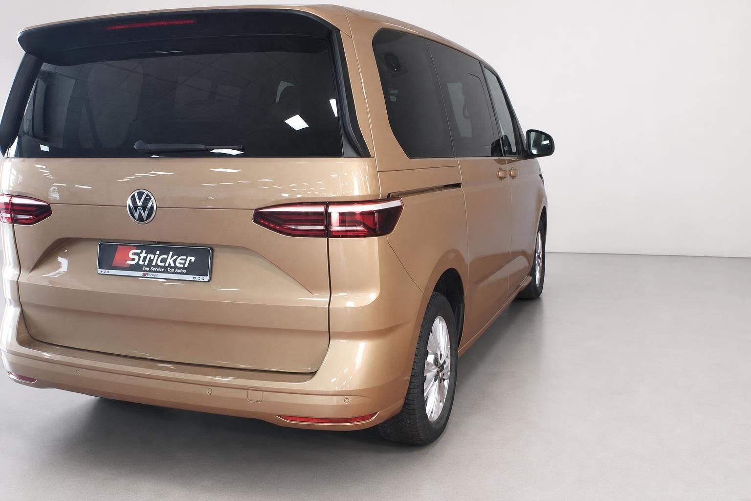 VW Multivan in Gold-Metallic, Heckansicht schräg
