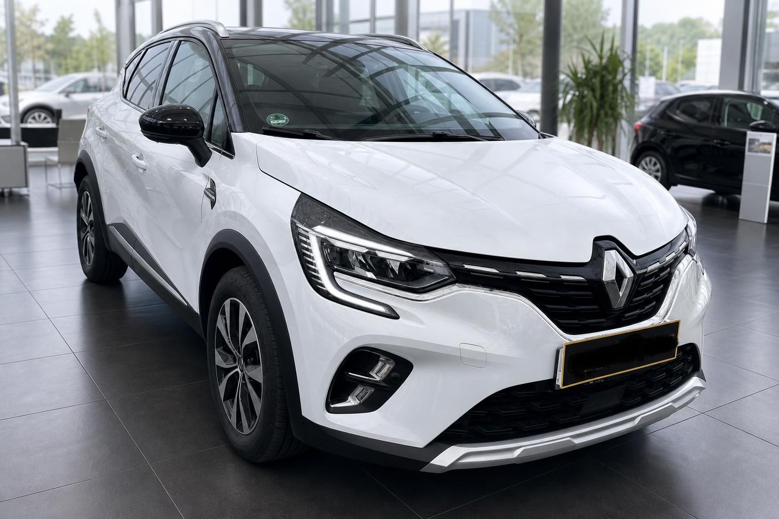 Weißer Renault Captur SUV im Autohaus-Showroom mit LED-Scheinwerfern und schwarzen Akzenten