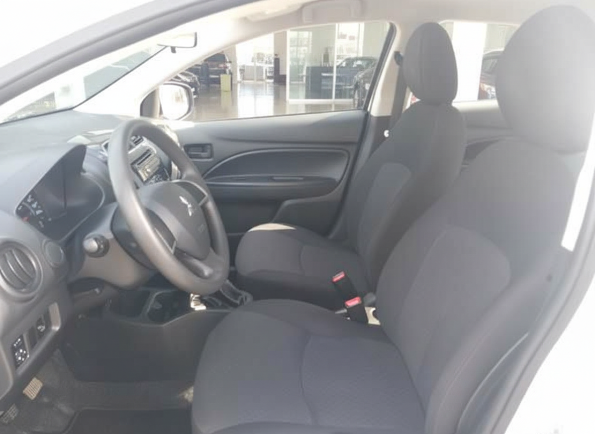 Mitsubishi Innenraum mit schwarzen Stoffsitzen, Lenkrad und Armaturenbrett in weißem Fahrzeug