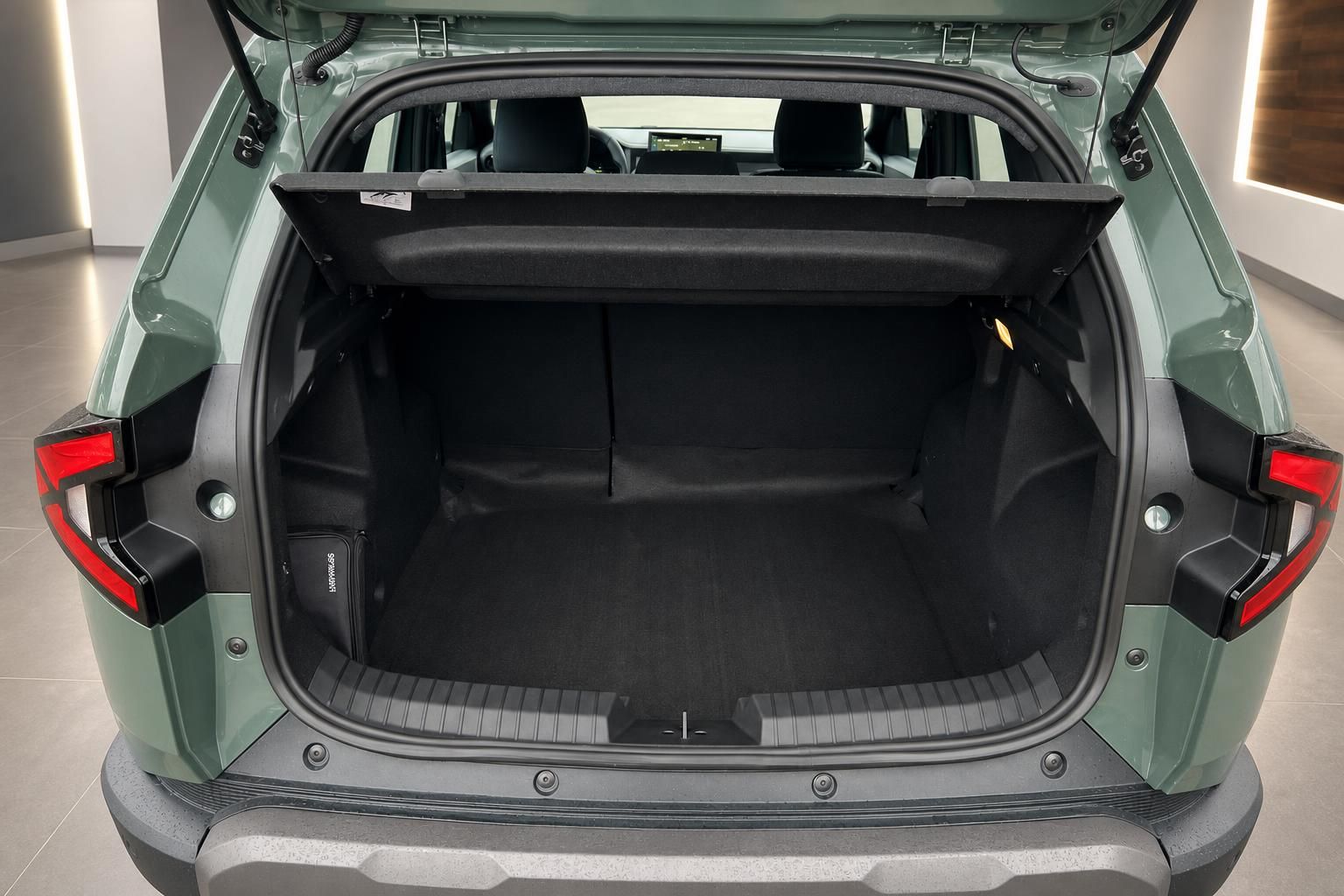 Geöffneter Kofferraum eines grünen SUVs mit schwarzer Innenausstattung und Ladeboden