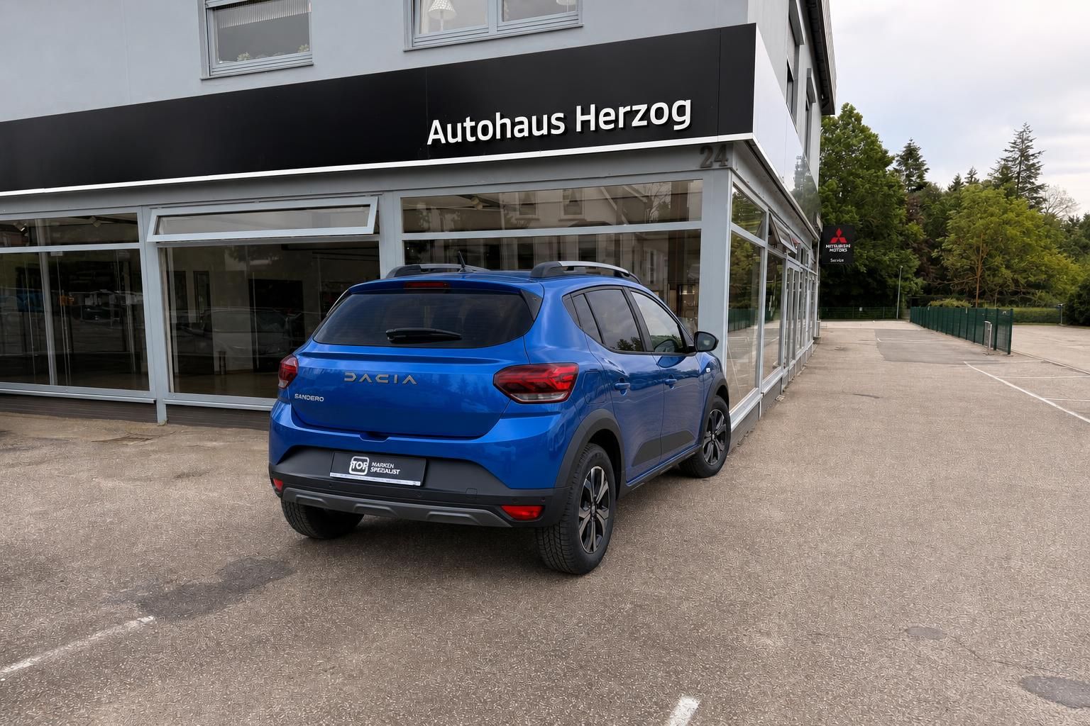 Dacia Sandero blau Heckansicht vor Autohaus Herzog - Gebrauchtwagen kaufen