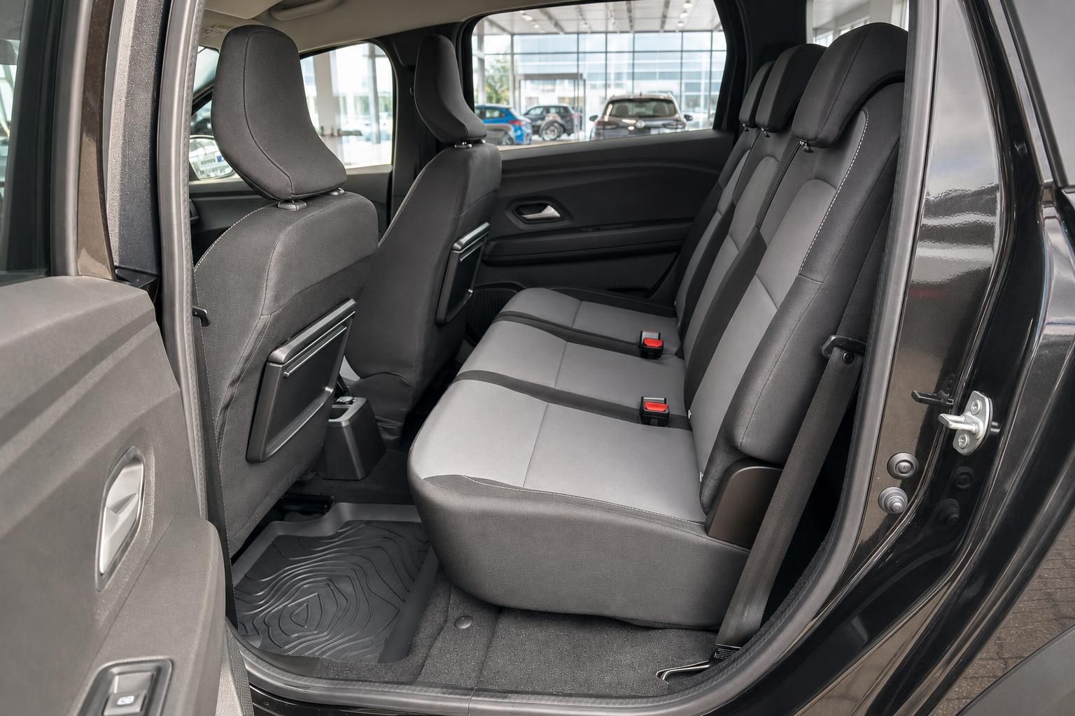 Dacia Rückbank mit grauen Stoffsitzen und Sicherheitsgurten im Fahrzeuginterieur