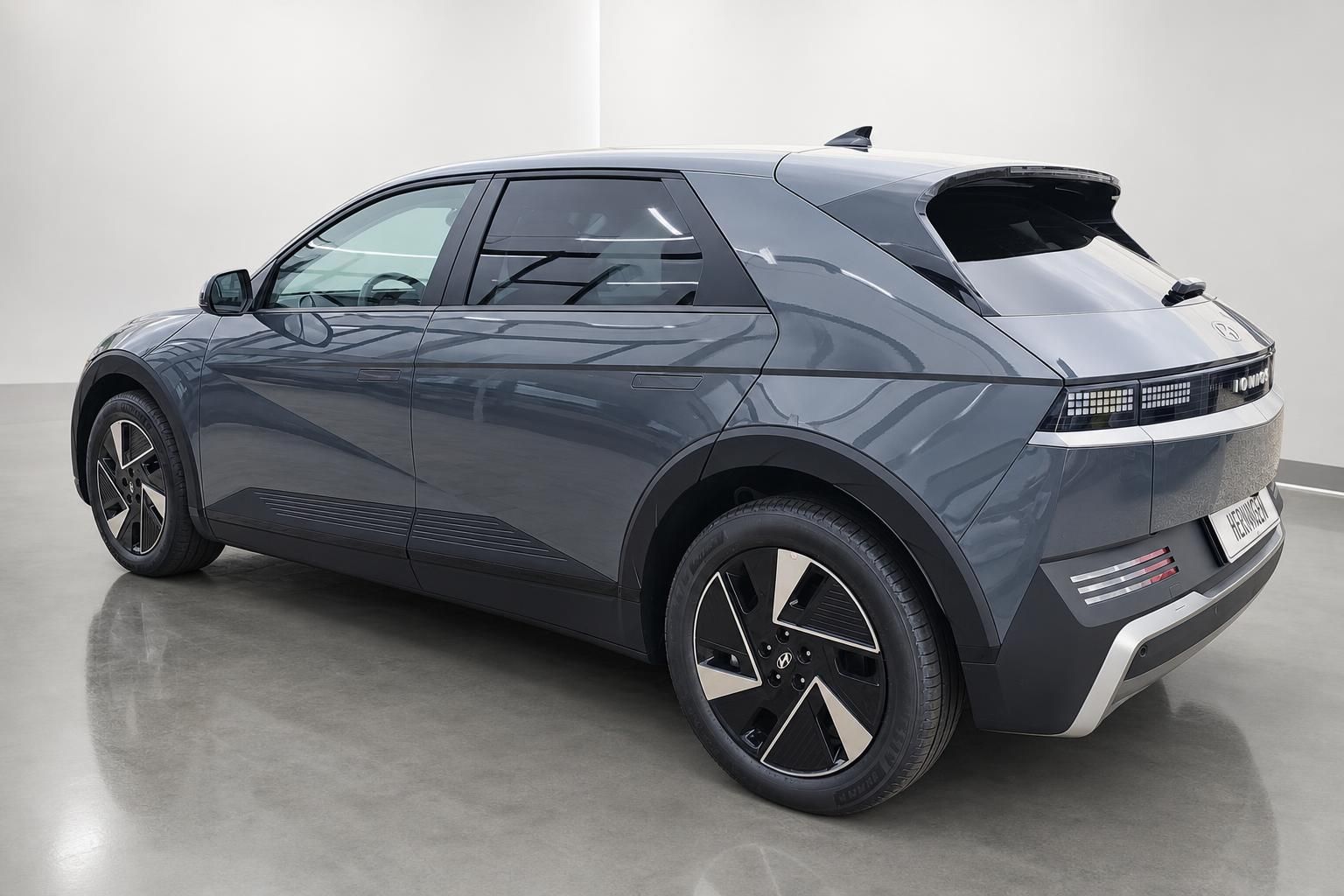 Hyundai Ioniq 5 grau, Heckansicht seitlich im Showroom
