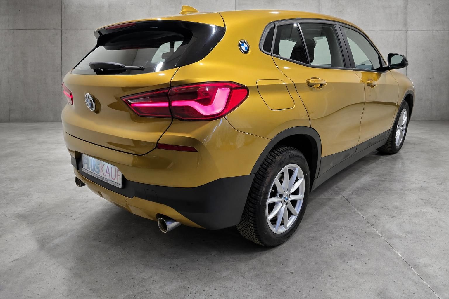 BMW X2 gold, Heckansicht schraeg mit Ruecklichtern