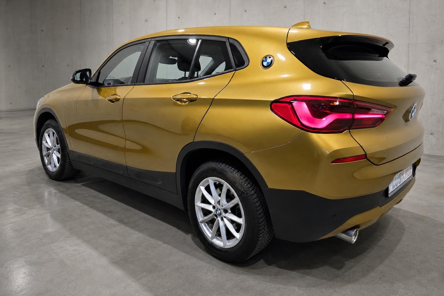 BMW X2 in Gold, Heck- und Seitenansicht im Studiolicht