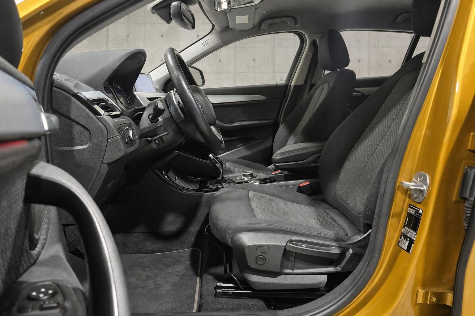 BMW X1 Innenraum Vordersitze und Cockpit von der Fahrertür aus