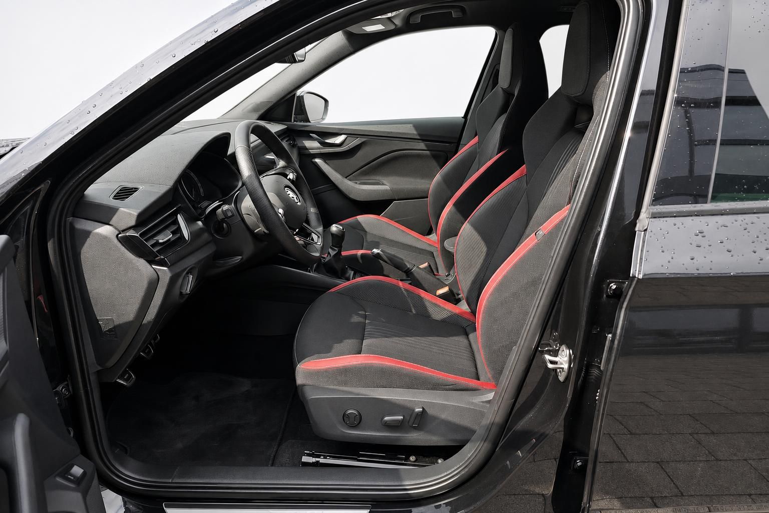 Skoda Innenraum mit schwarz-roten Sportsitzen und geöffneter Fahrertür