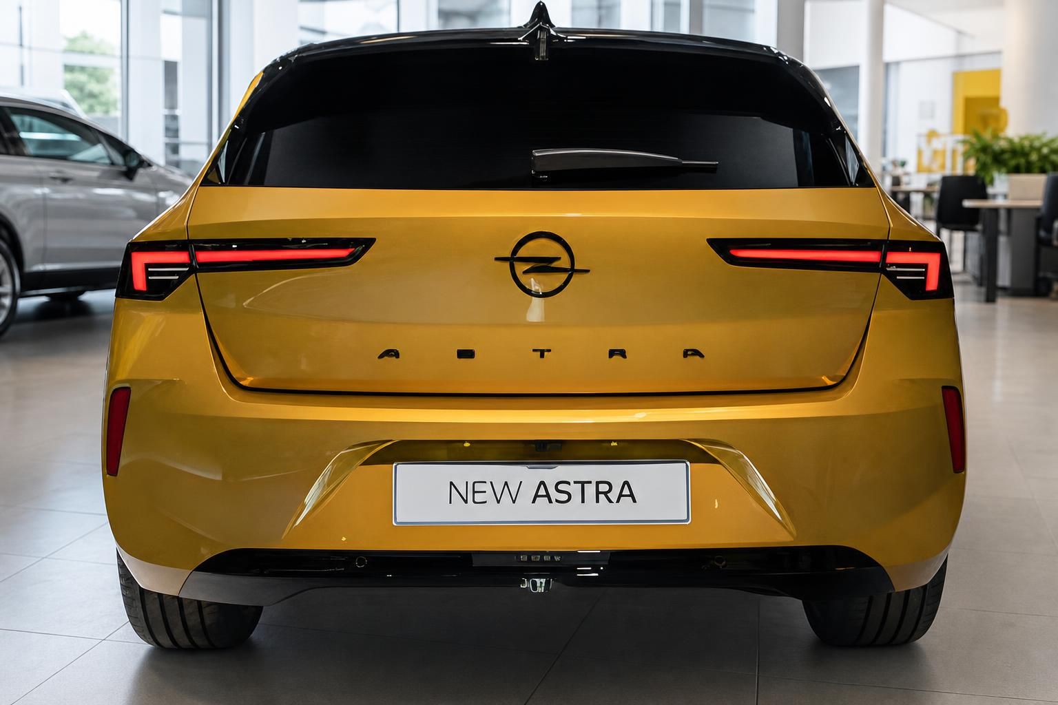Opel Astra in Gelb, Heckansicht mit Rueckleuchten im Showroom