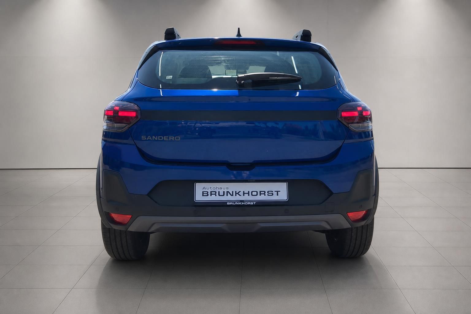 Dacia Sandero blau, Heckansicht mit Rücklichtern im Autohaus Brunkhorst