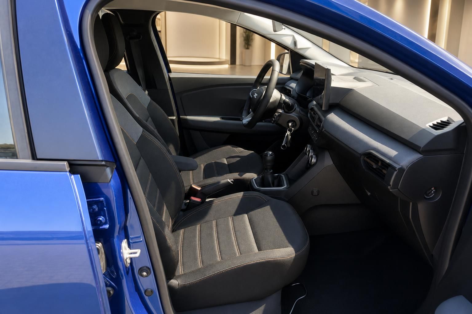 Dacia Sandero blau, Innenraum mit Vordersitzen und geöffneter Tür