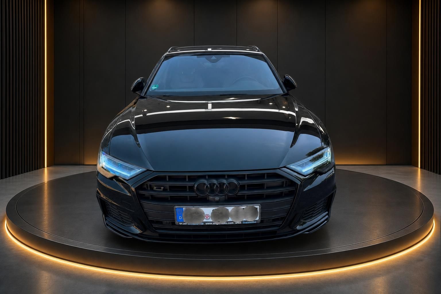Schwarzer Audi A6 Limousine Frontansicht mit LED-Scheinwerfern auf beleuchteter Drehbühne
