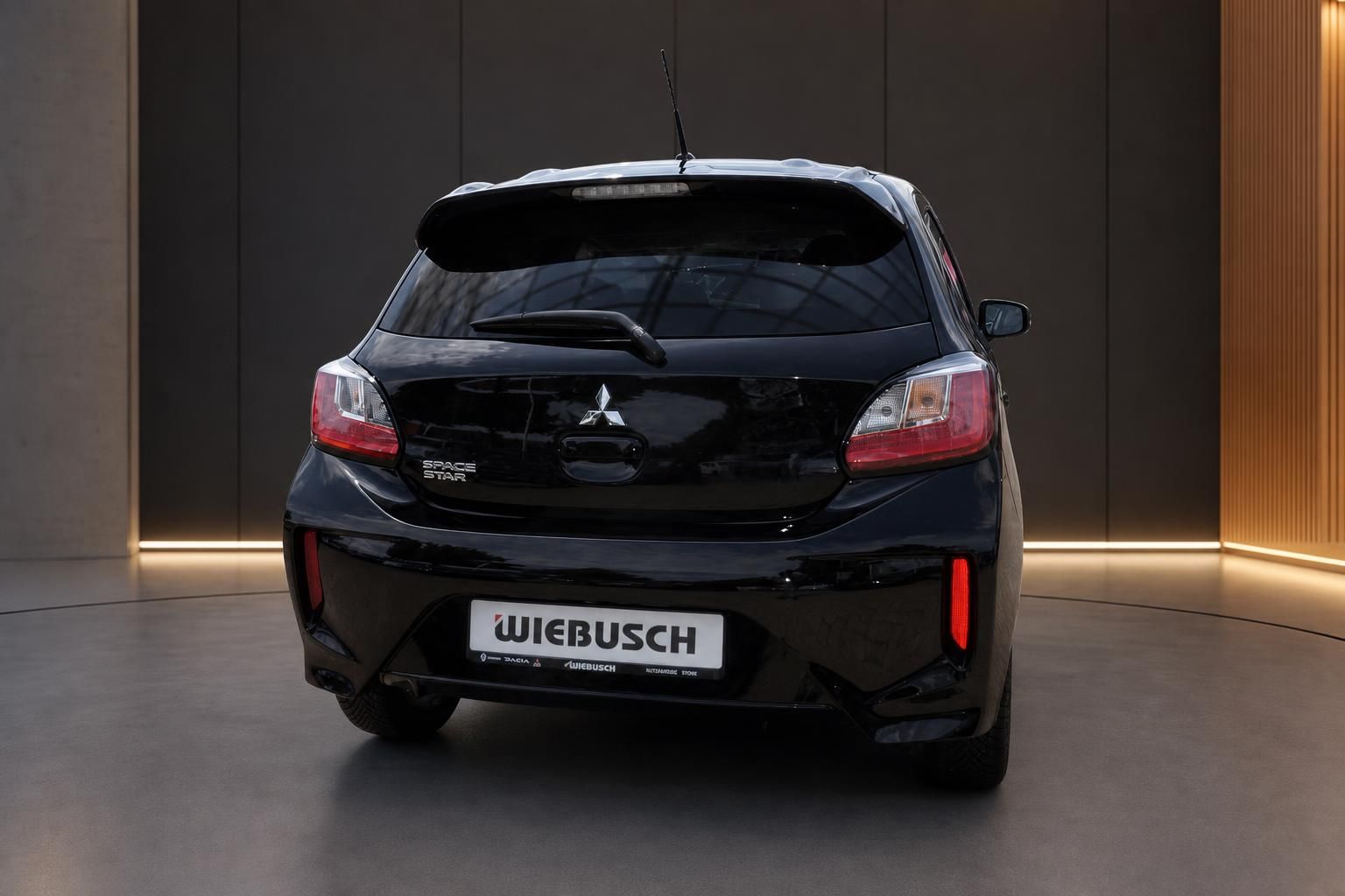 Mitsubishi Space Star schwarz Heckansicht – schwarzer Kleinwagen in modernem Showroom