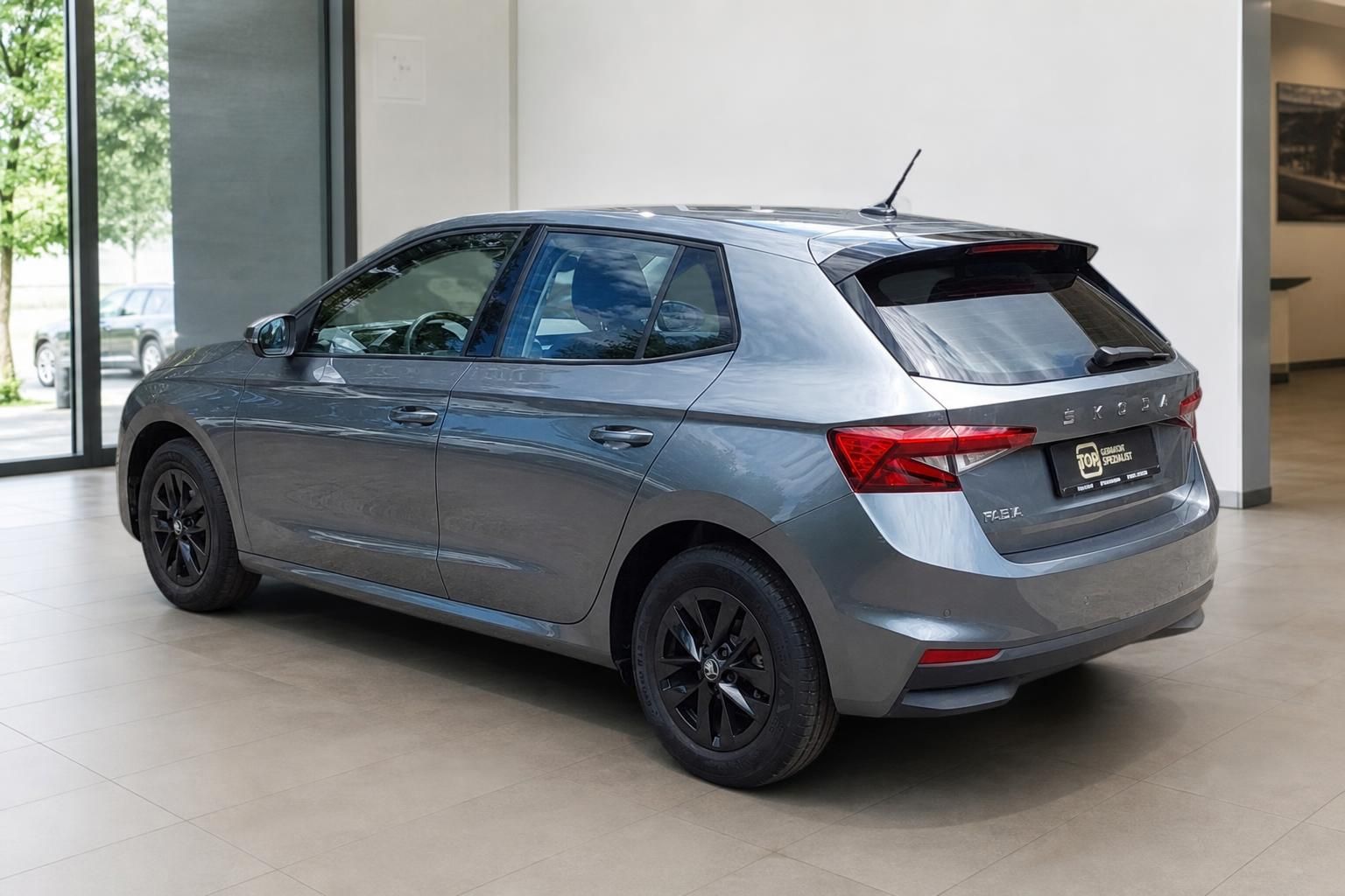 Skoda Fabia grau Heckansicht schräg mit schwarzen Felgen im Autohaus
