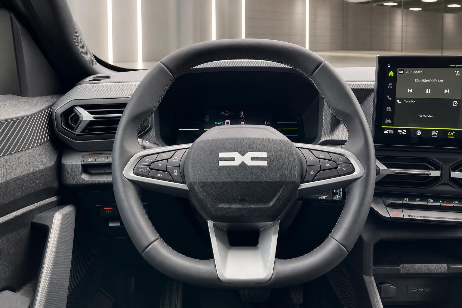 Lenkrad mit Multifunktionstasten und Cockpit-Display im Fahrzeuginnenraum