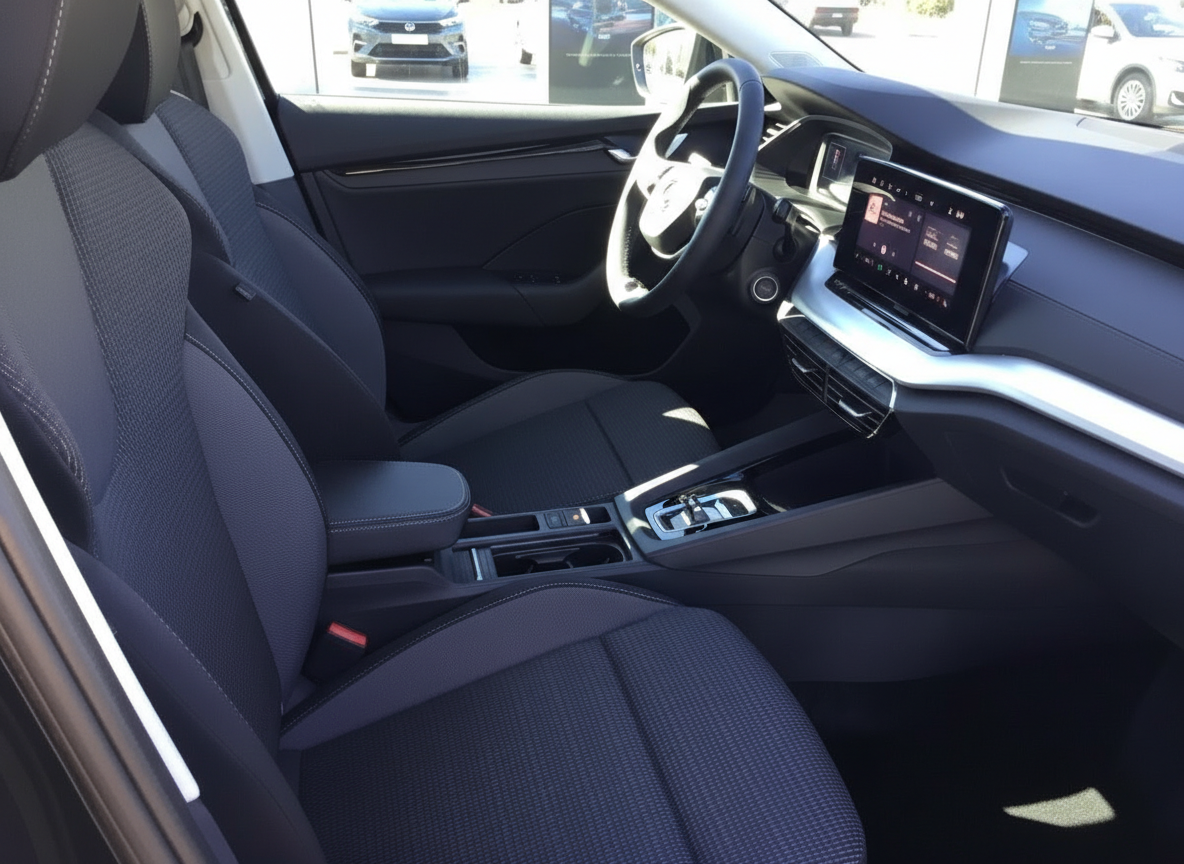 Fahrzeuginnenraum mit schwarzen Stoffsitzen, Touchscreen-Infotainment und modernem Cockpit